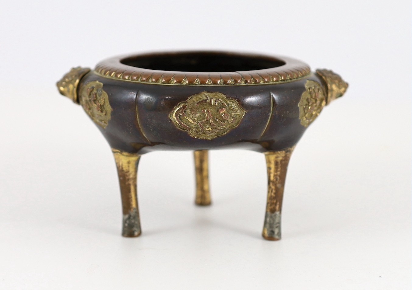 A Chinese Imperial copper alloy censer, ding, 18th century, 12cm wide 7cm high, ring handles and cover lacking, some wear.